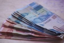 Tumpukan uang rupiah mewakili gaji pekerja yang bebas PPh 21 tahun 2026.