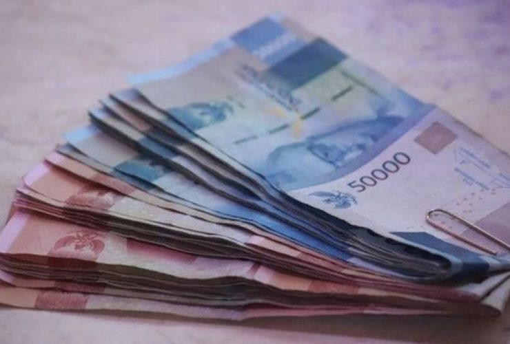 Tumpukan uang rupiah mewakili gaji pekerja yang bebas PPh 21 tahun 2026.