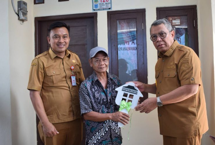 Pejabat Disperkimta Kota Tangerang Selatan bersama warga penerima bantuan saat penyerahan simbolis program bedah rumah atau Rumah Tidak Layak Huni (RUTLH).