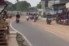 Pengendara melintas di Jalan Aria Putra Ciputat, Tangerang Selatan, di tengah debu tebal akibat aktivitas truk pengangkut tanah.