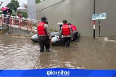 Personel Polda Metro Jaya mengevakuasi warga menggunakan perahu karet saat banjir merendam Asrama Polisi Pondok Karya, Jakarta Selatan