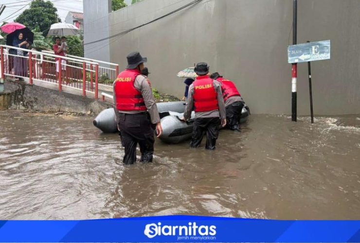 Personel Polda Metro Jaya mengevakuasi warga menggunakan perahu karet saat banjir merendam Asrama Polisi Pondok Karya, Jakarta Selatan