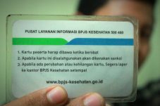 Ilustrasi kartu Jamkesda dan BPJS Kesehatan dengan latar rumah sakit di Kota Serang sebagai simbol jaminan layanan kesehatan bagi warga kurang mampu.