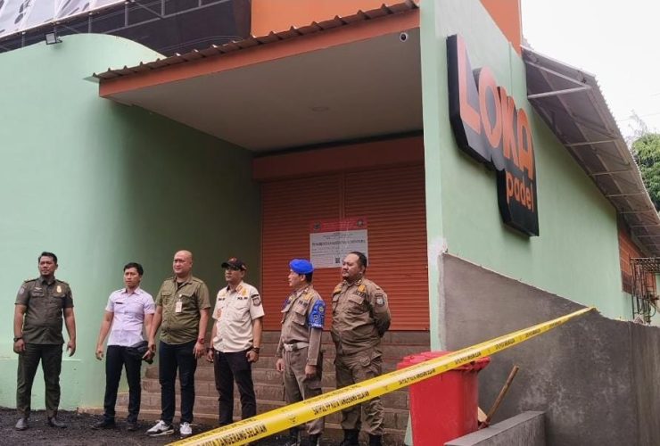 Petugas Satpol PP Tangsel dan PPNS berdiri di depan bangunan Loka Padel Tandon Ciater yang disegel karena belum memiliki izin PBG.