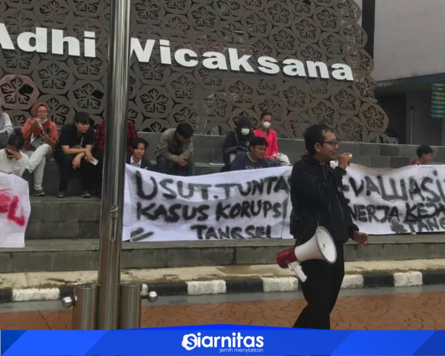 Aksi mahasiswa di depan kantor Kejari Kota Tangerang Selatan membawa spanduk tuntutan pengusutan kasus dugaan korupsi terkait Loka Padel.