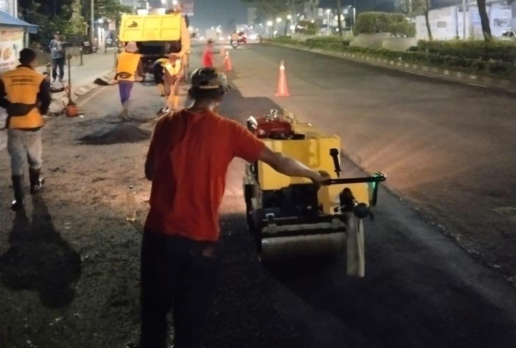 Petugas Dinas SDABMBK Kota Tangerang Selatan melakukan perbaikan jalan pada malam hari melalui program sapu lubang jelang libur Lebaran 2026.