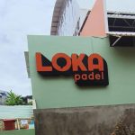 Tampak depan bangunan Loka Padel di Jalan Tandon Ciater, Serpong, Tangerang Selatan, dengan papan nama berwarna oranye dan hitam menempel di dinding hijau.