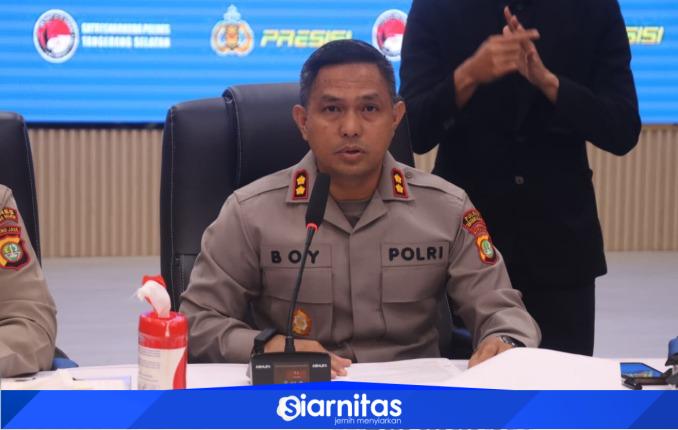 Kapolres Tangerang Selatan mengenakan seragam Polri saat memberikan keterangan pers di ruang konferensi, dengan papan nama “Kapolres” di meja dan petugas bahasa isyarat di belakangnya.